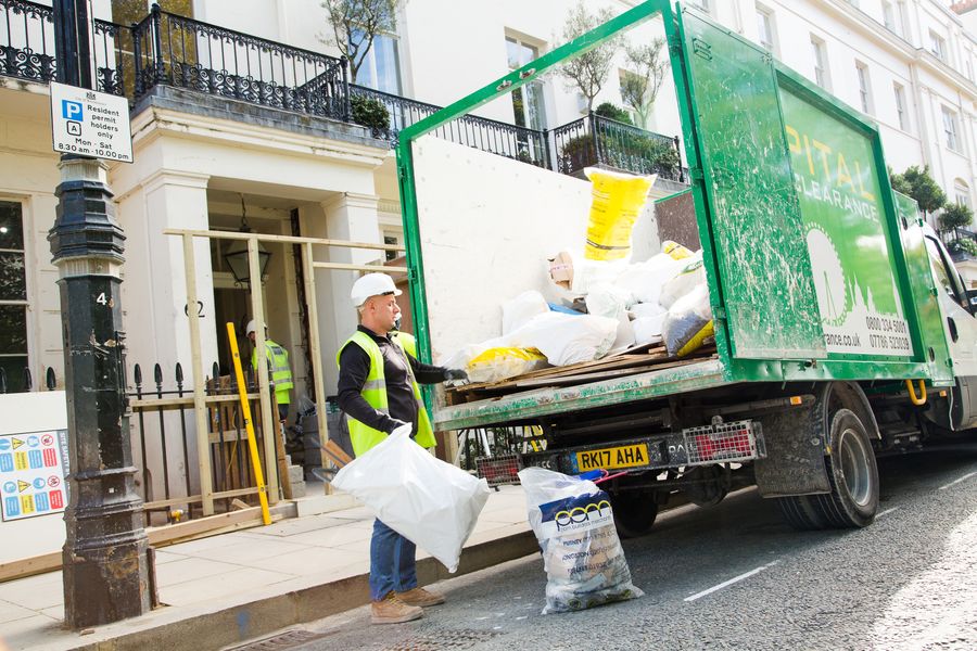 Capital Waste Clearance operative carrying bagged waste from a London townhouse